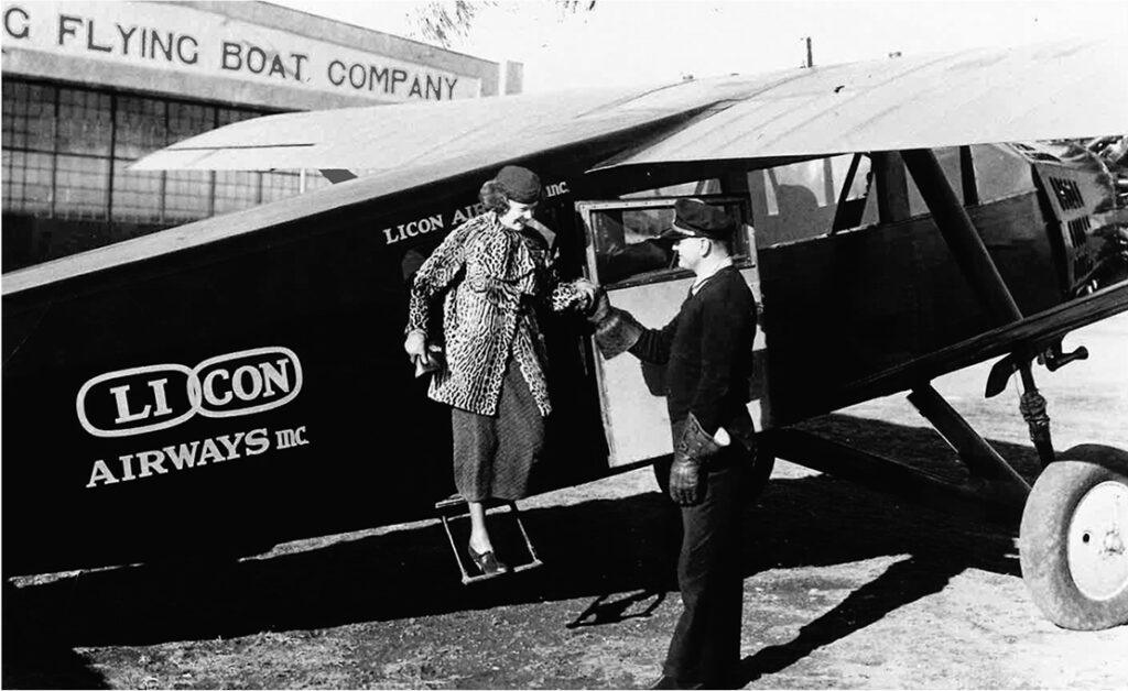 1933 - Photograph of a man helping a woman disembark from a Long Island - Connecticut Airways airplane